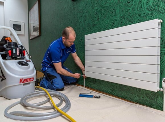 man fixing radiator